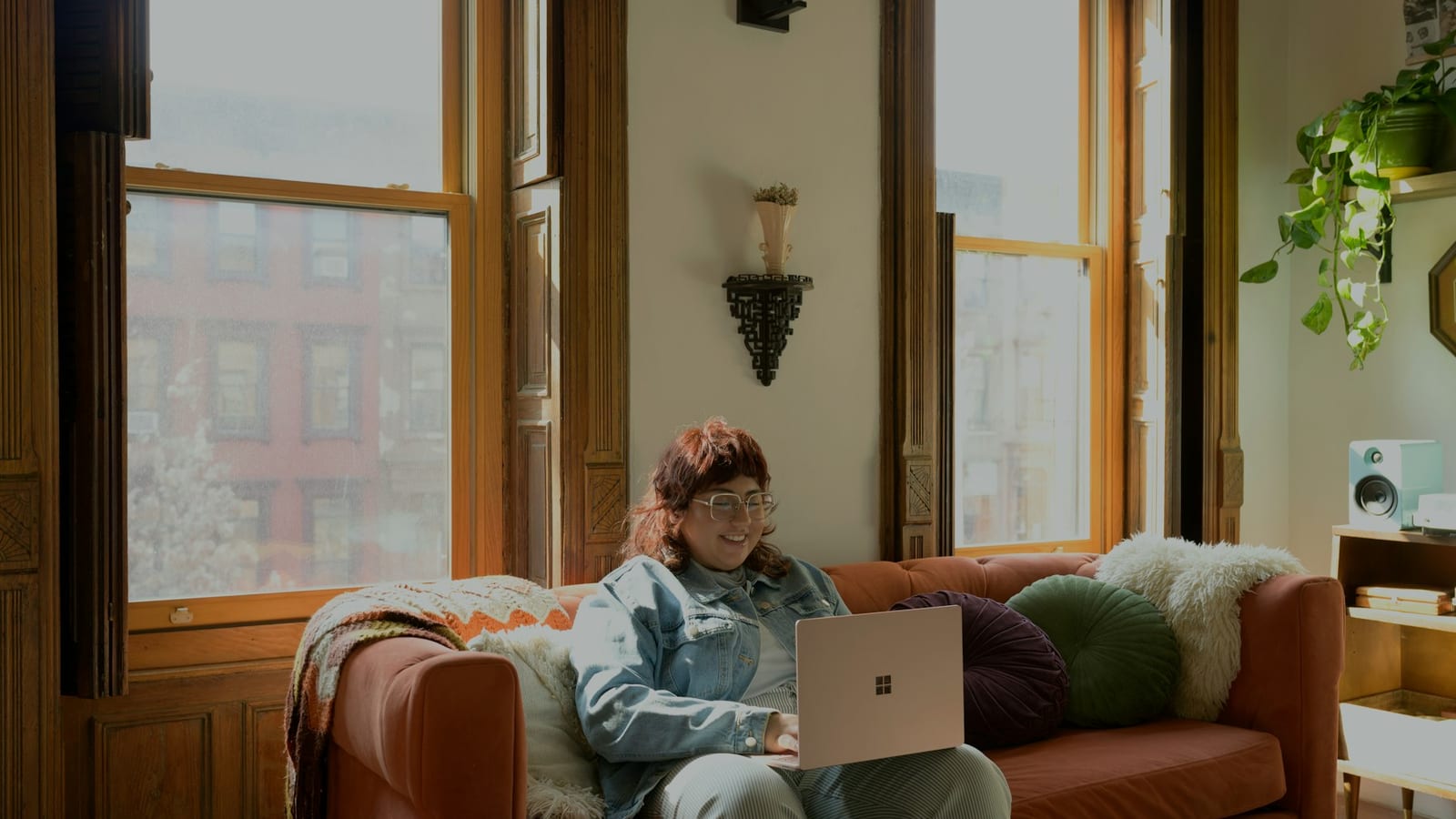 A remote professional working on a laptop in a bright, warm room