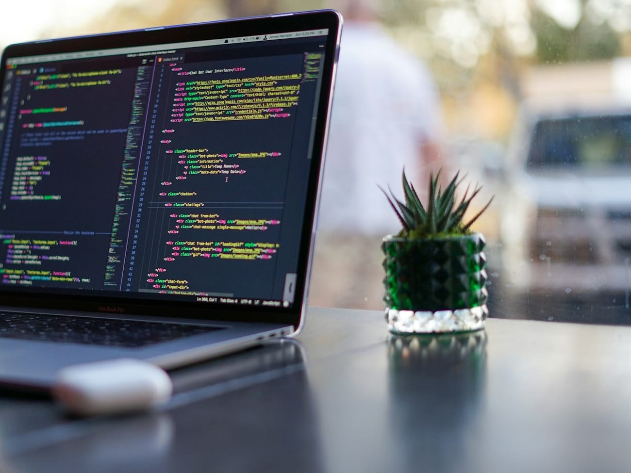 A laptop showing software being written